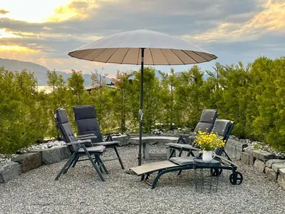 two chairs and a table with an umbrella at Summer villa with heated pool 50 min from Bergen