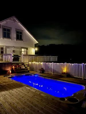 a swimming pool in front of a house at night at Summer villa with heated pool 50 min from Bergen