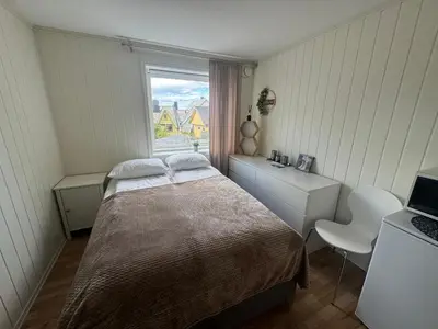 a small bedroom with a bed and a window at Alesund center room with double bed in Ålesund