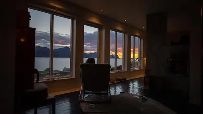 a room with a chair in a room with windows at Posthuset Expedition Lodge in Lii
