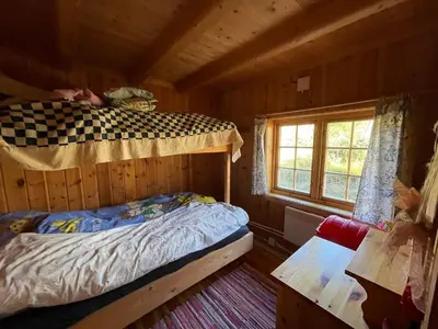 a bedroom with a bunk bed in a log cabin at Thorpeset cabin by Norgesbooking - cabin with amazing view in Uvdal