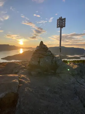 a cross on top of a mountain at sunset at Petersstova in Ålesund