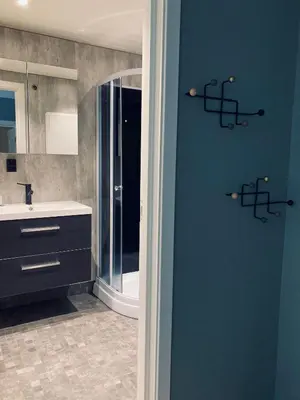 a bathroom with a blue wall with a sink at Petersstova in Ålesund