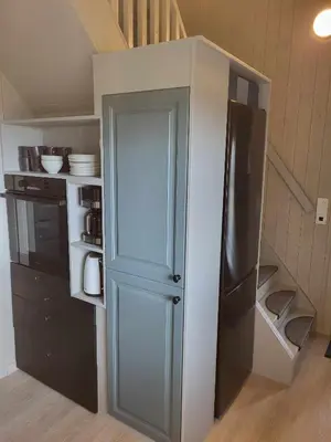 a small kitchen with a refrigerator in a room at Koselig liten fjellhytte i flott turterreng både sommer og vinter in Hovda