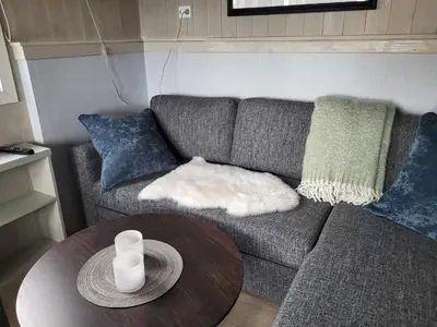 a living room with a couch and a table at Koselig liten fjellhytte i flott turterreng både sommer og vinter in Hovda