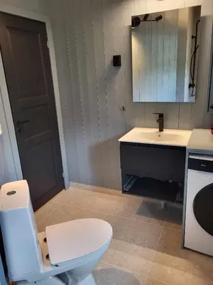a bathroom with a white toilet and a sink at Koselig liten fjellhytte i flott turterreng både sommer og vinter in Hovda