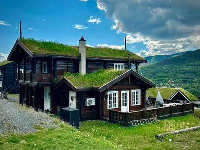 a house with a grass roof on top of it at Stylish log cabin in Hafjell with view & sauna in Hafjell