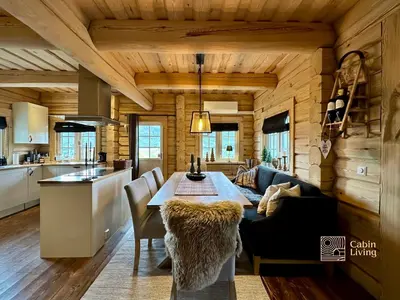 a kitchen and dining room with a table in a room at Stylish log cabin in Hafjell with view & sauna in Hafjell