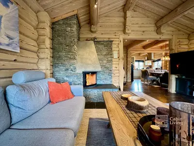a living room with a couch and a fireplace at Stylish log cabin in Hafjell with view & sauna in Hafjell