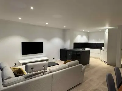 a living room with a couch and a flat screen tv at Modern Apartment in City Center with Parking Garage in Ålesund