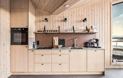 a kitchen with wooden cabinets and a sink at 4 Bedroom Awesome Home In Vøringsfoss in Maurset