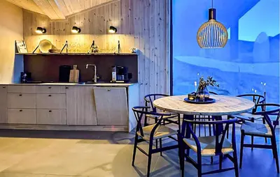 a dining room with a table and chairs and a kitchen at 4 Bedroom Awesome Home In Vøringsfoss in Maurset
