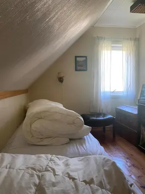 a bedroom with a bed with a pillow and a window at Cozy house closw in Lii