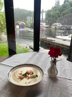 a plate of food on a table with a vase of flowers at Cozy house closw in Lii