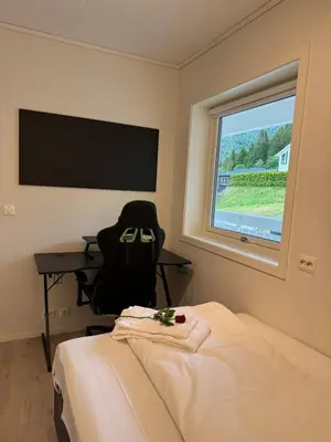 a room with a bed and a desk and a window at Loen Panorama View in Loen