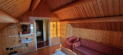 a bathroom with a sink and a red couch at Lauvåsen - Langleiken in Sør-Fron