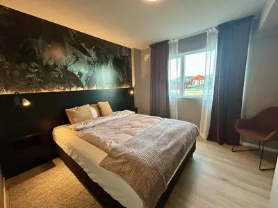 a bedroom with a bed with a large painting on the wall at Apartment Suite in Os in Osøyro