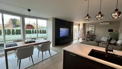 a kitchen and living room with a table and chairs at Apartment Suite in Os in Osøyro