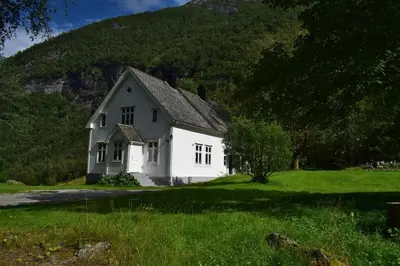 a white house with a hill in the background at Large house by nature reserve