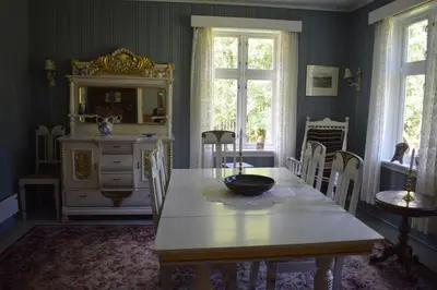 a dining room with a table and a room with a kitchen at Large house by nature reserve