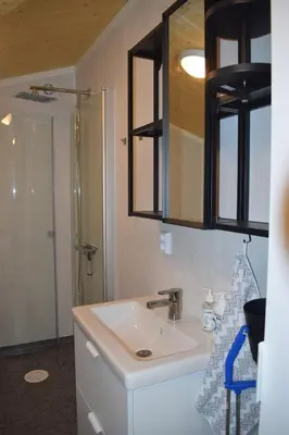 a bathroom with a sink and a shower at Skogshytte in Bjordal
