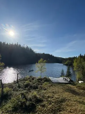 a boat sitting on the shore of a lake at Lakeside cabin in Snofugl