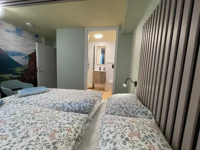 a bedroom with two beds and a painting on the wall at Bakkebo in Åndalsnes