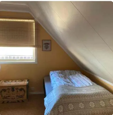 a small bedroom with a bed and a window at Lilletun in Selbu