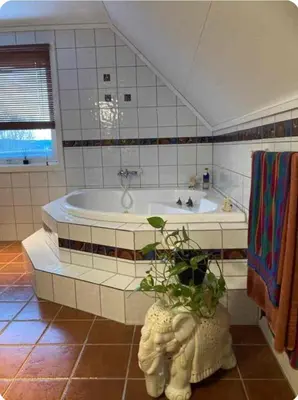 a bathroom with a tub and a potted plant at Lilletun in Selbu