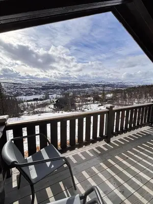 a balcony with a chair and a view of a city at Modernized Log Cabin With Views Of The Mountains in Ron