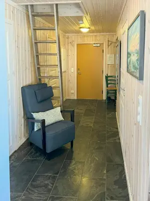 a hallway with a blue chair and a yellow door at Family-Friendly Mountain Cabin In Haukeli in Nesland