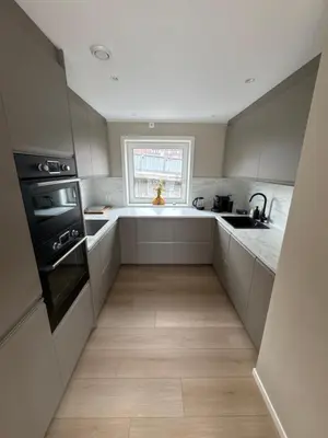 a kitchen with white cabinets and a sink and a window at Daniels House in Kristiansund