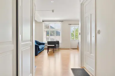 an open door to a living room with a blue couch at 4-Bedroom Apartment with Balcony in Odda