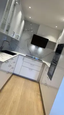 a kitchen with white cabinets and a wooden floor at Trondheim in Trondheim