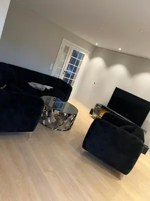 a living room with two black couches and a table at Trondheim in Trondheim