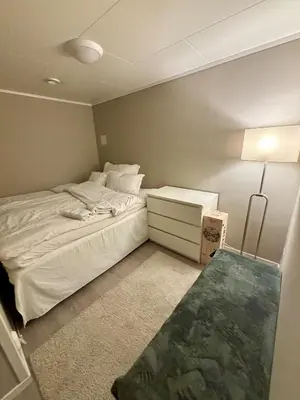 a small bedroom with a bed and a night stand at Central apartment in Bergen City Center in Bergen