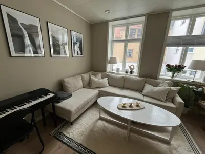 a living room with a couch and a piano at Central apartment in Bergen City Center in Bergen
