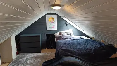 a room with a bed in a attic at Koselig hus med egen brygge in Askøy