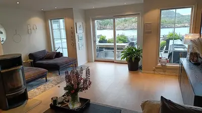 a living room with a couch and a table at Koselig hus med egen brygge in Askøy