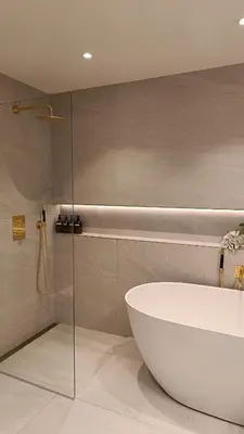 a bathroom with a tub and a glass shower at Koselig hus med egen brygge in Askøy