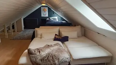 a living room with a couch in a attic at Koselig hus med egen brygge in Askøy