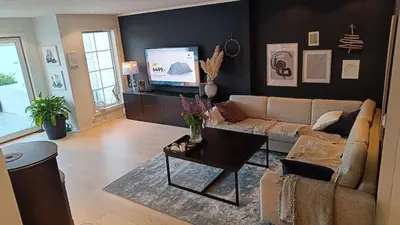 a living room with a couch and a tv at Koselig hus med egen brygge in Askøy