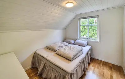 a bed in a small room with a window at Cozy Home In Lepsøy With House Sea View in Lepsøy