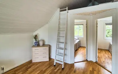 a room with a ladder and a dresser and a bedroom at Cozy Home In Lepsøy With House Sea View in Lepsøy