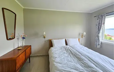 a bedroom with a bed and a dresser and a mirror at Awesome Home In Fitjar With Wifi in Fitjar
