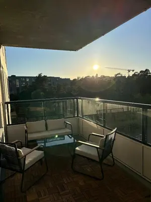 a balcony with two chairs and a table and a bench at Lys og moderne 3-roms på Sandsli in Bergen