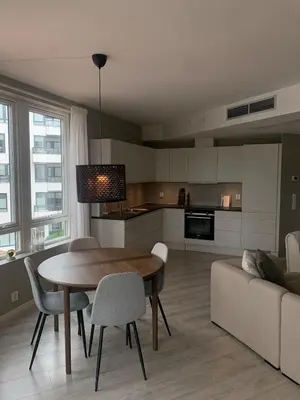 a kitchen and living room with a table and a couch at Lys og moderne 3-roms på Sandsli in Bergen