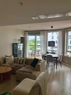 a living room with a couch and a table at Lys og moderne 3-roms på Sandsli in Bergen