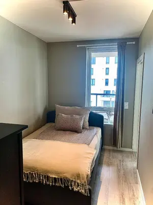 a bed in a room with a window at Lys og moderne 3-roms på Sandsli in Bergen