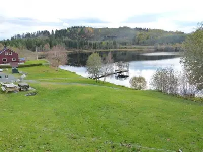 a view of a lake with a bridge and a house at Cabin at Hestsjøen Badeplass in Trondheim